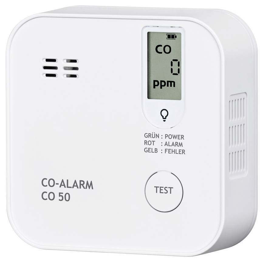A rectangular carbon monoxide detector with a digital display shows 'CO 0 ppm'. Three LEDs: Green for power, Red for alarm, Yellow for fault. A large test button is located beneath.