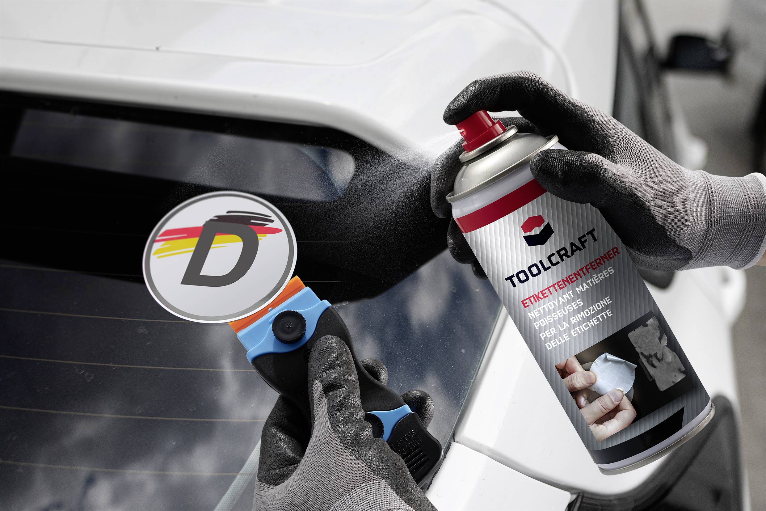 A person is spraying lubricant from an aerosol can onto the rear window of a car. In their other hand, they are holding a tool with a 'D' symbol.