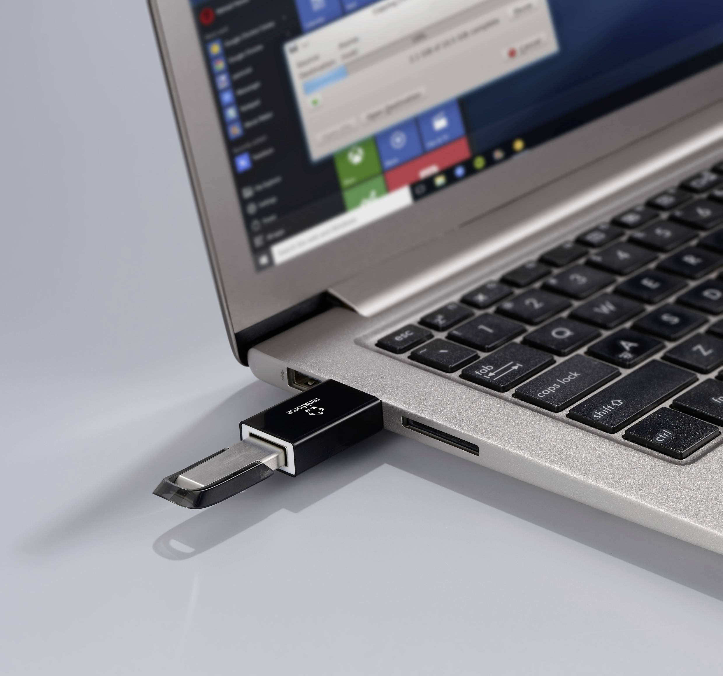 A laptop with a USB stick plugged in displays an open dialogue on the screen, offering options for executing the device.