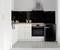 Modern kitchen with white furnishings, black splashback and small black fridge. Surfaces are clean and tidy.