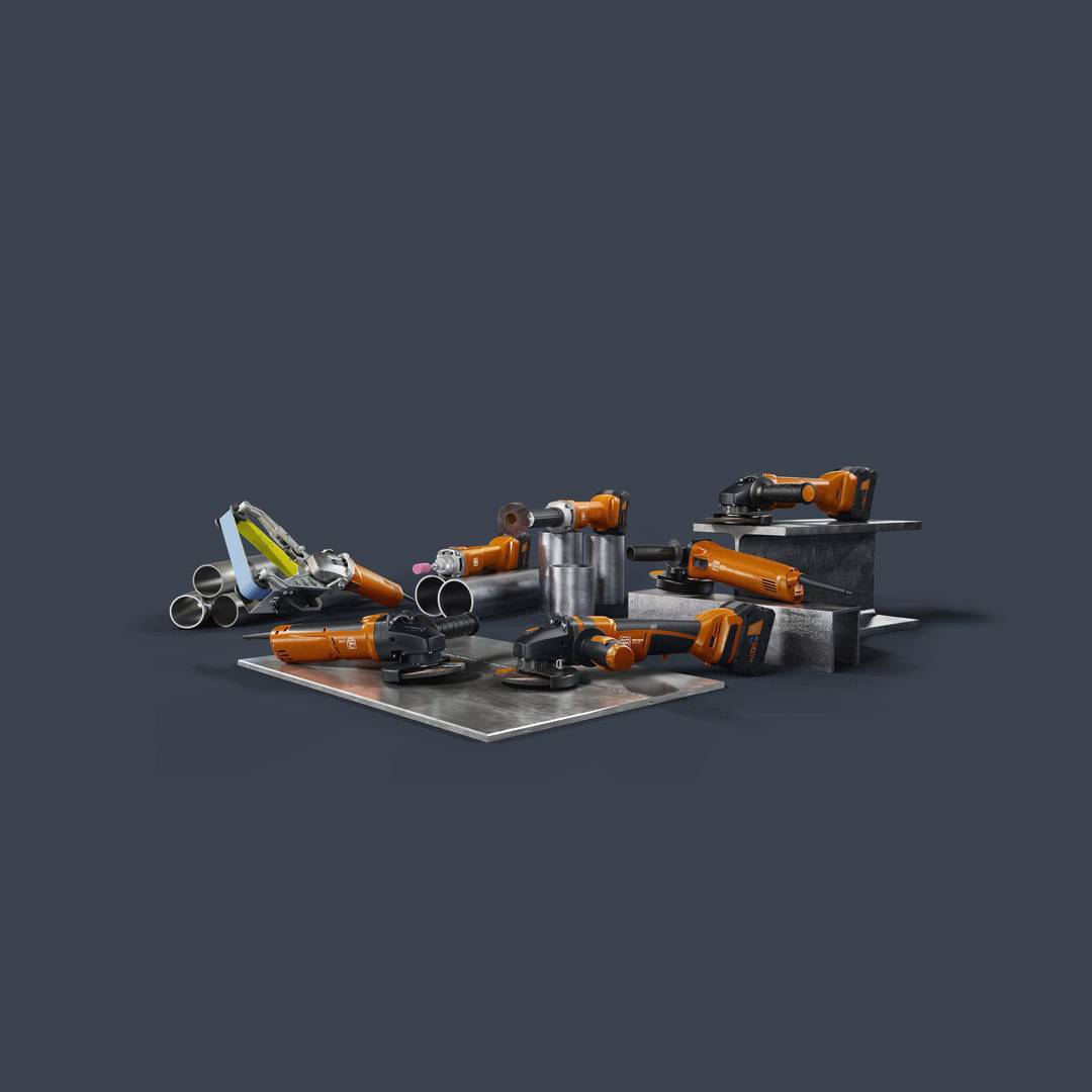 Industrial robotic arms made of metal with various tool attachments, arranged on a table for manufacturing processes.