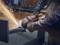 A person is grinding metal with an angle grinder. Sparks are flying in all directions as the machine smooths the metal edge.
