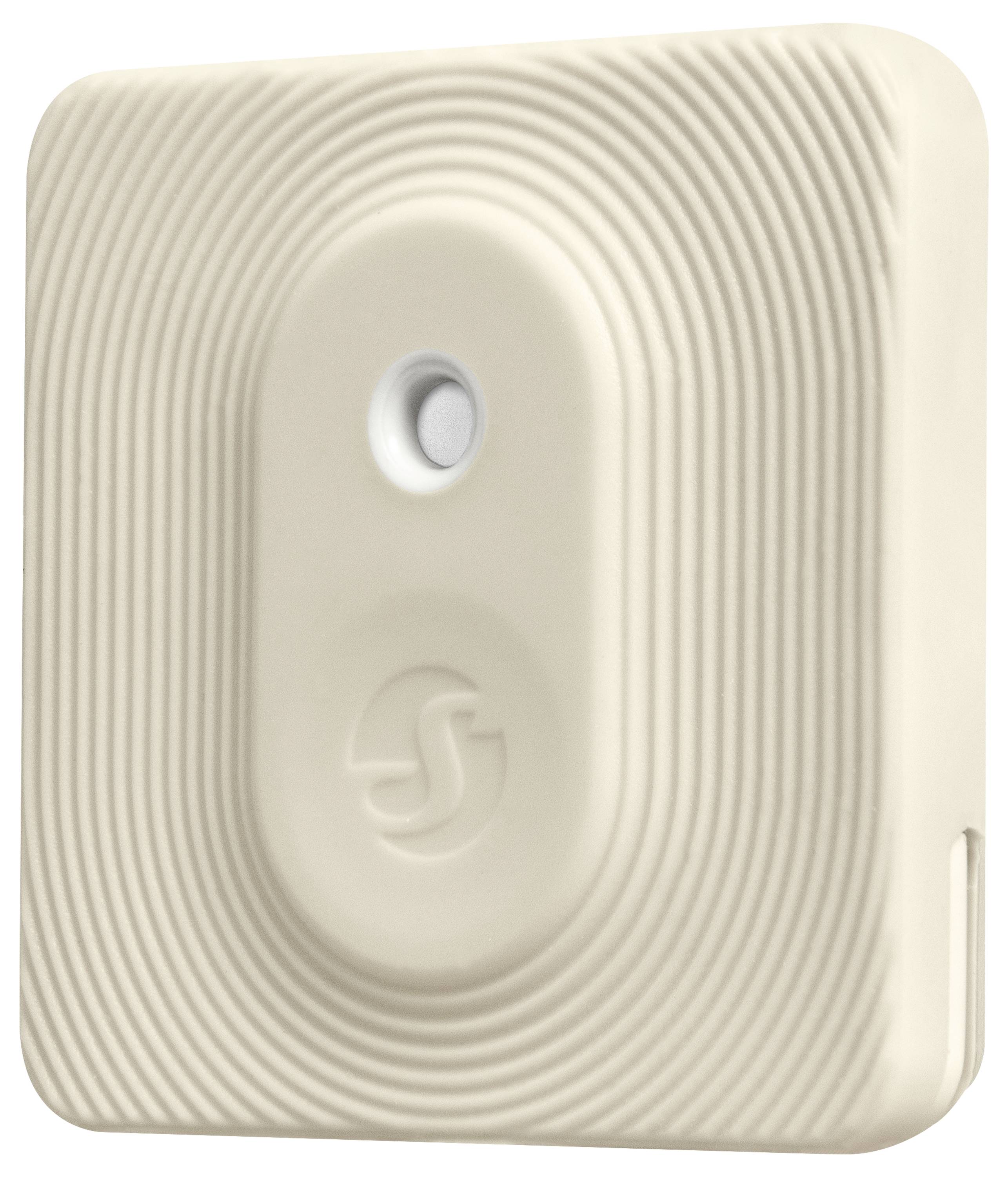 A cream-coloured, square smoke detector with concentric circles on the surface and a central button.