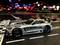 Toy safety car on a racing track with colourful lights in the background.
