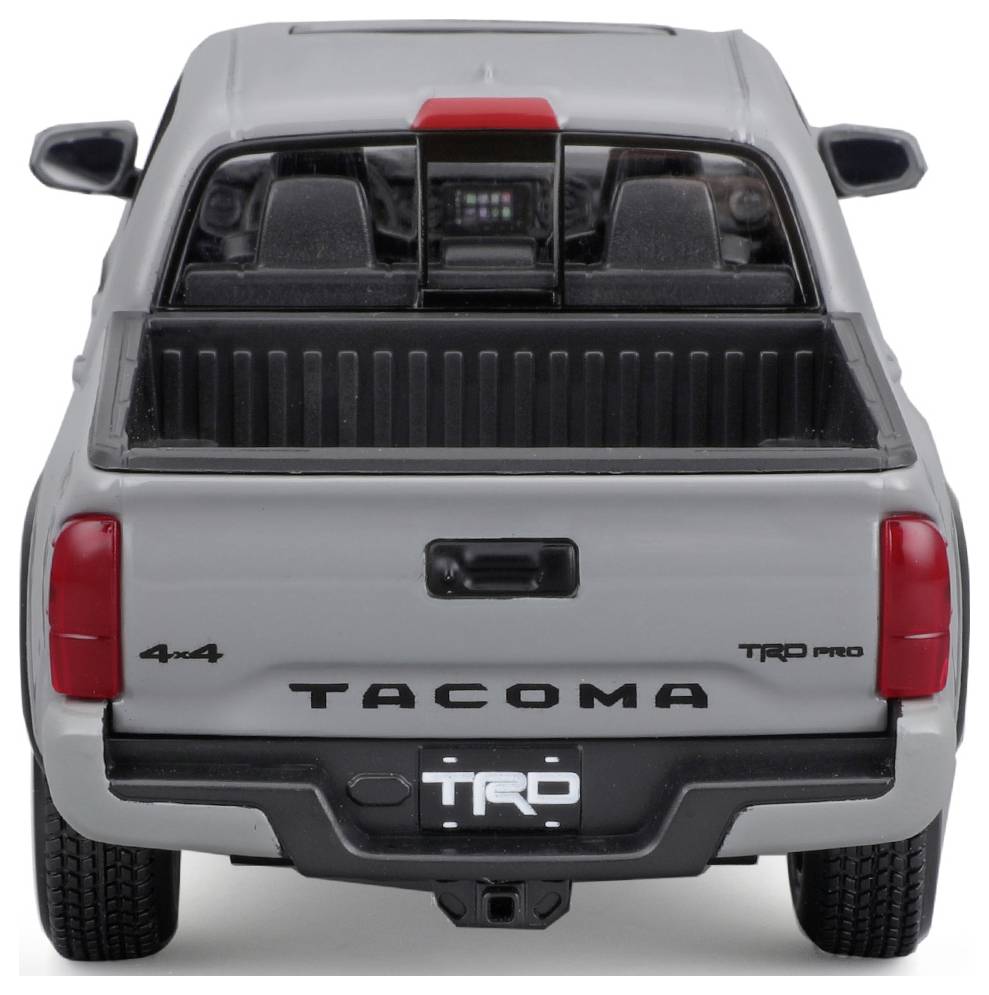 Grey-silver pickup truck viewed from behind, with an open load bed and 'TACOMA' lettering, red accents, TRD Pro model.