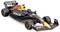 A black Formula 1 racing car with red and yellow accents, brand logos, and a driver in the cockpit. Racing car with aerodynamic design.