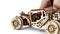 Wooden model of a car with visible gears and mechanisms, being touched by a hand.
