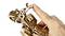 A finger is turning a wooden model kit. The intricate design reveals gears and structures that emphasise mechanical expertise.