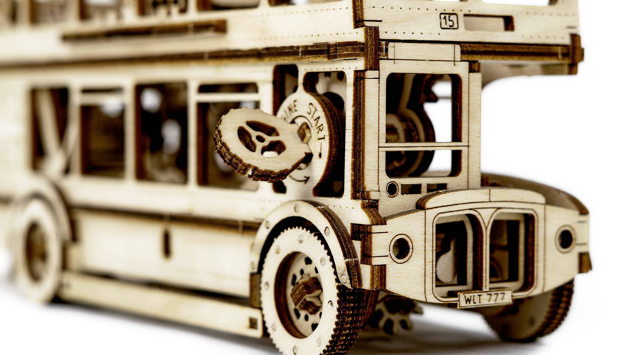 Wooden model of a historic double-decker bus with visible details such as wheels, windows, and gears, symbolising nostalgia.