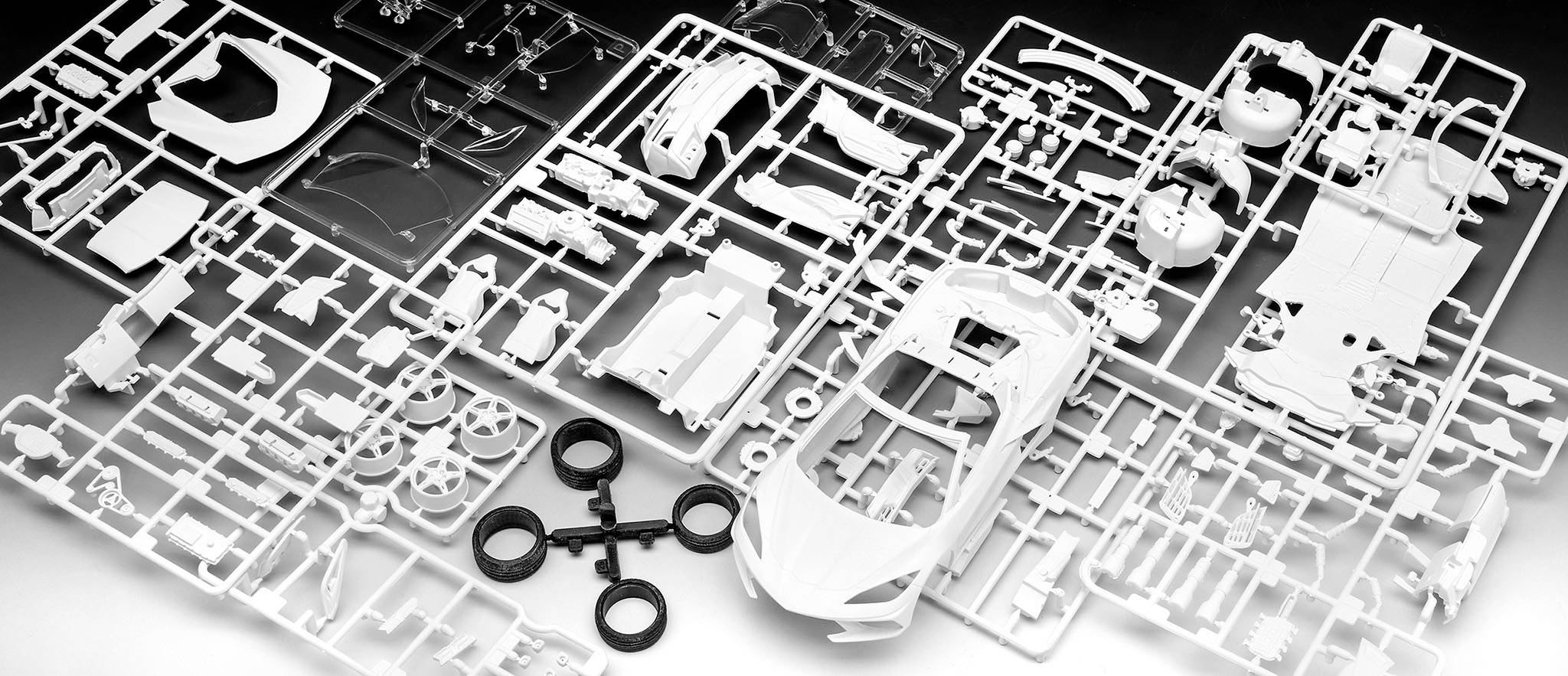 Model car kit, consisting of several casting frames with plastic car parts, partially assembled.