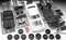 Plastic parts of a model car in individual components, including bodywork, wheels and accessories, laid out for assembly on a grey surface.
