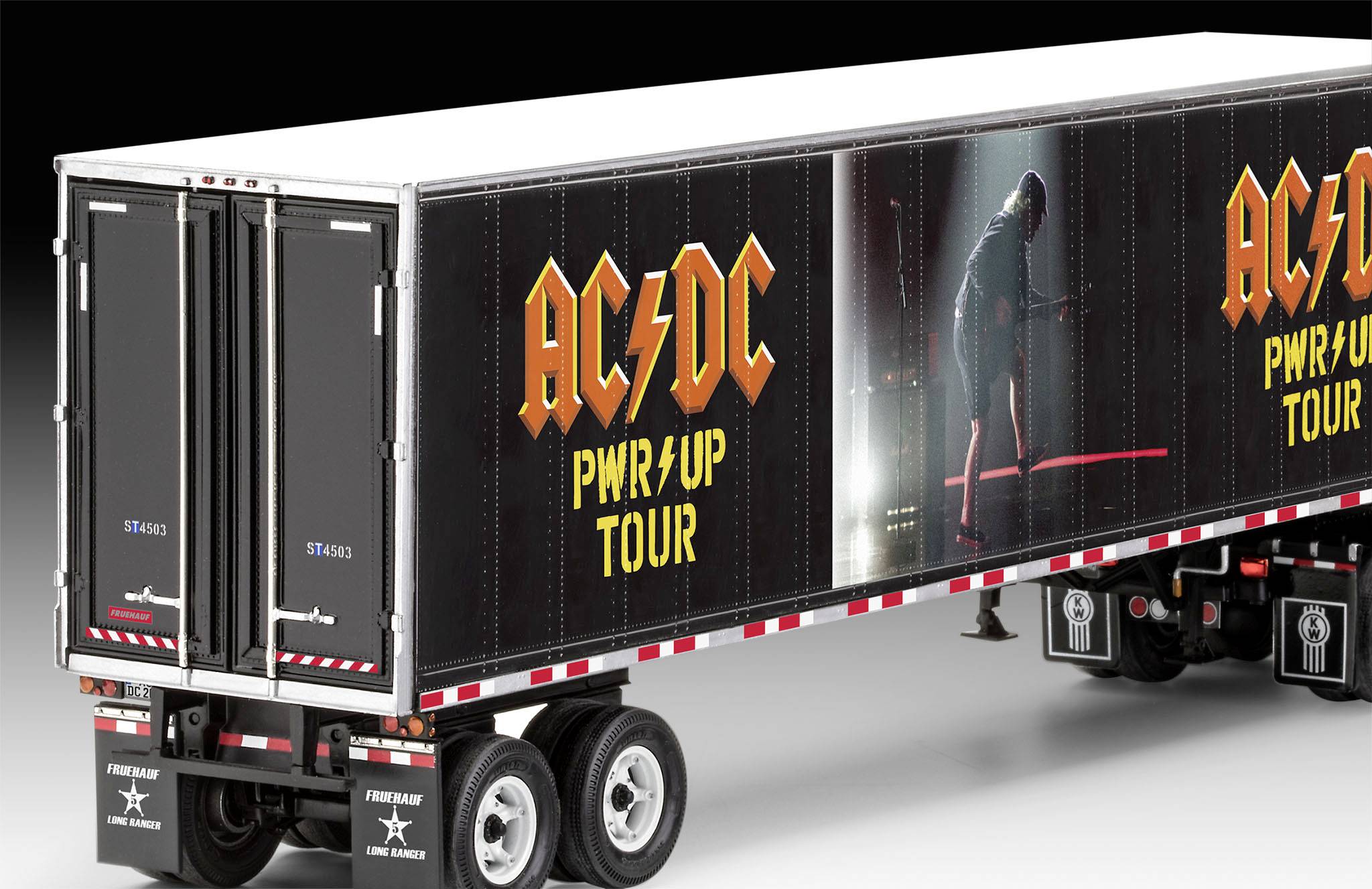 A lorry trailer with the inscription 'AC/DC PWR/UP Tour'. On the side, one can see a figure in a concert pose with red lighting.