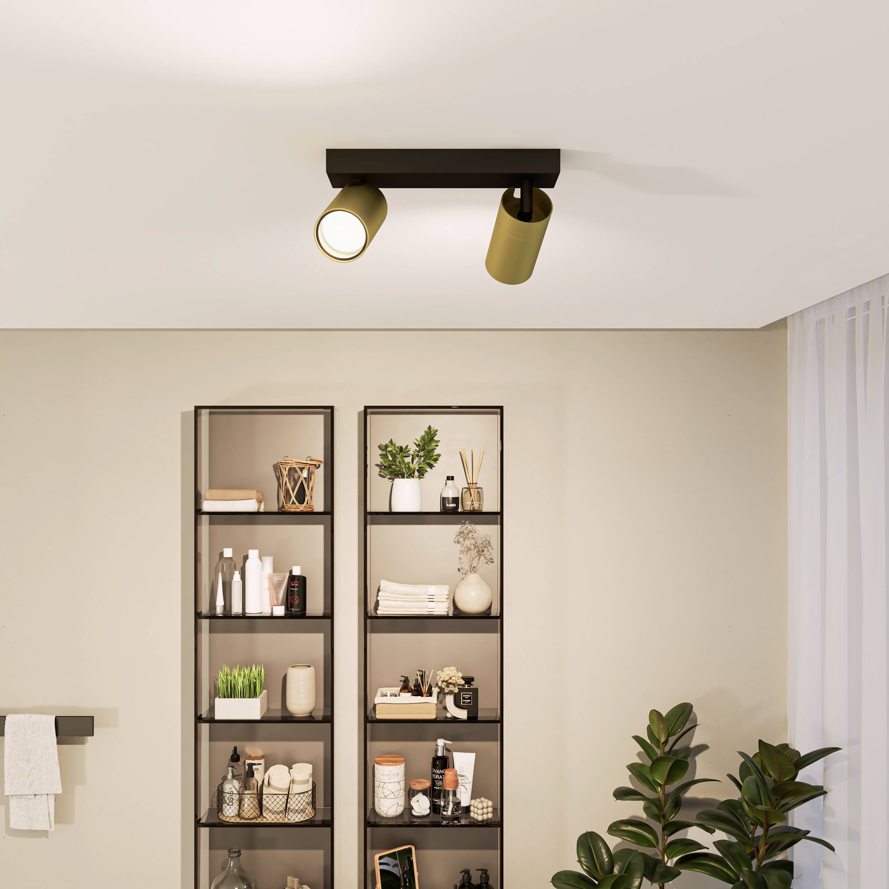 A simple bathroom shelf with a towel rail, stocked with toiletries and towels; above it, a contemporary ceiling light.