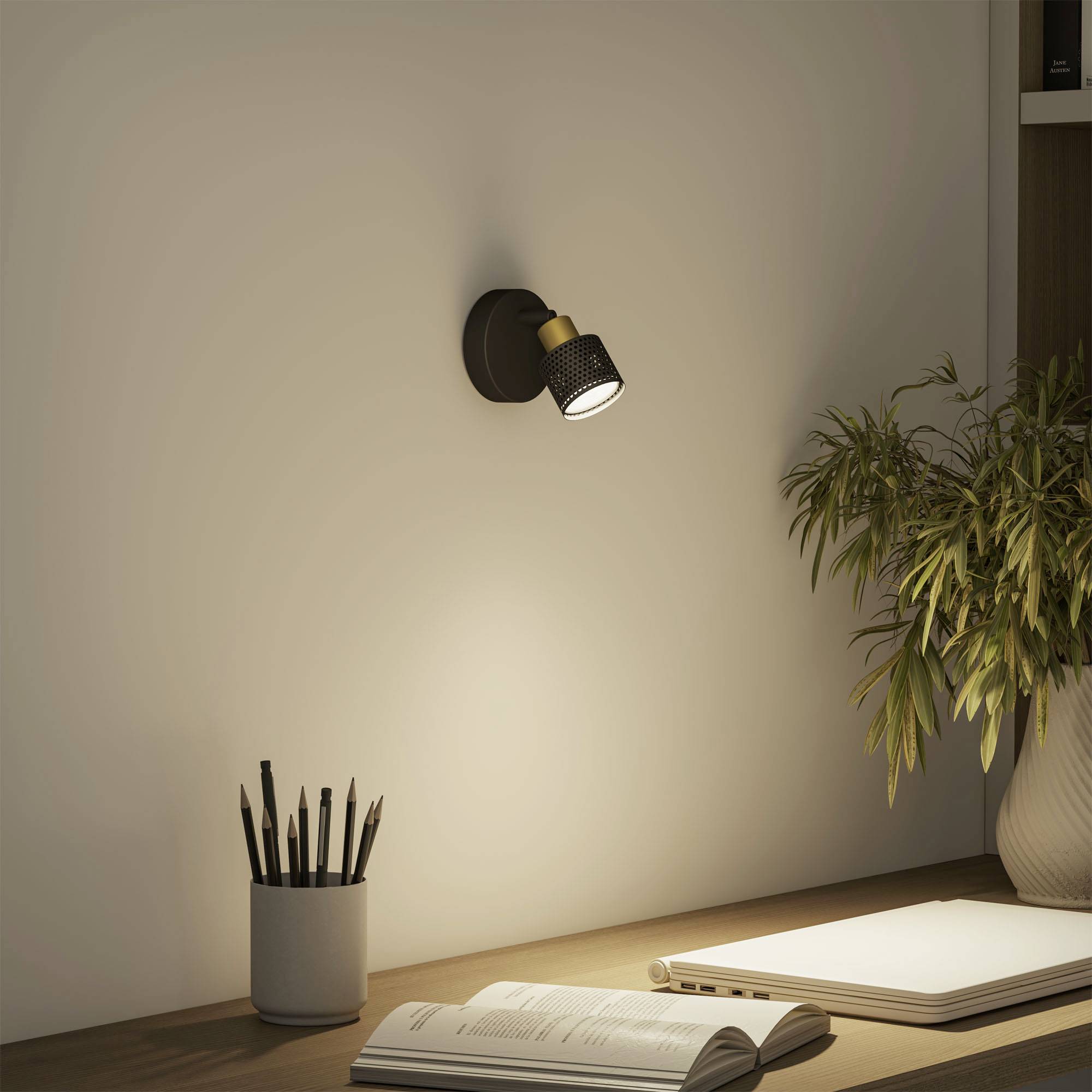 A desk with an open notebook, pen, and desk lamp illuminates an area. A plant stands beside the table.