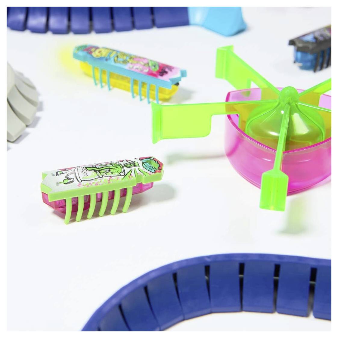 Several colourful, mechanical toy insects on a light surface, simulating various movements.