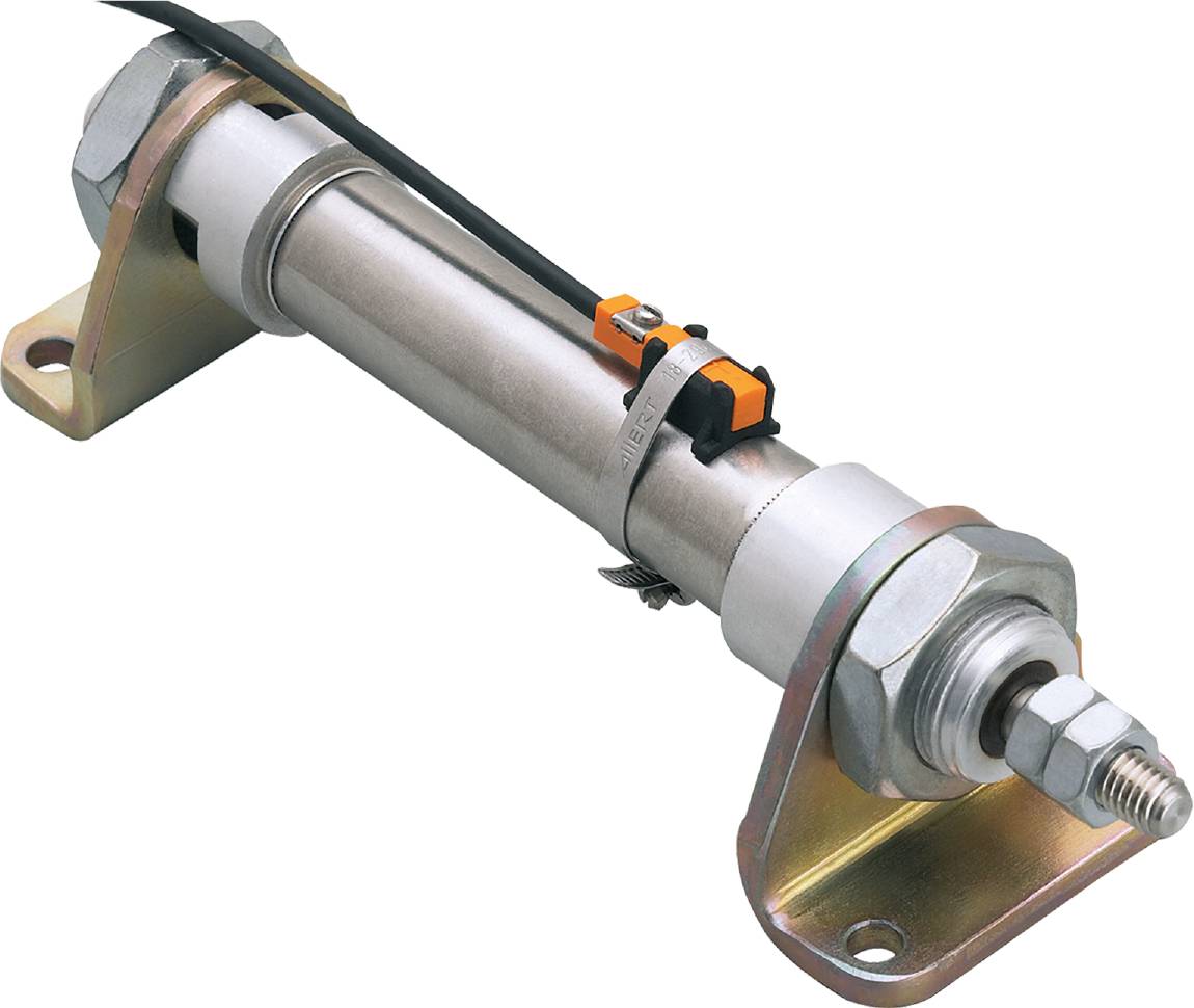 A hydraulic cylinder with a metallic housing and connectors, mounted on a bracket against a black background.
