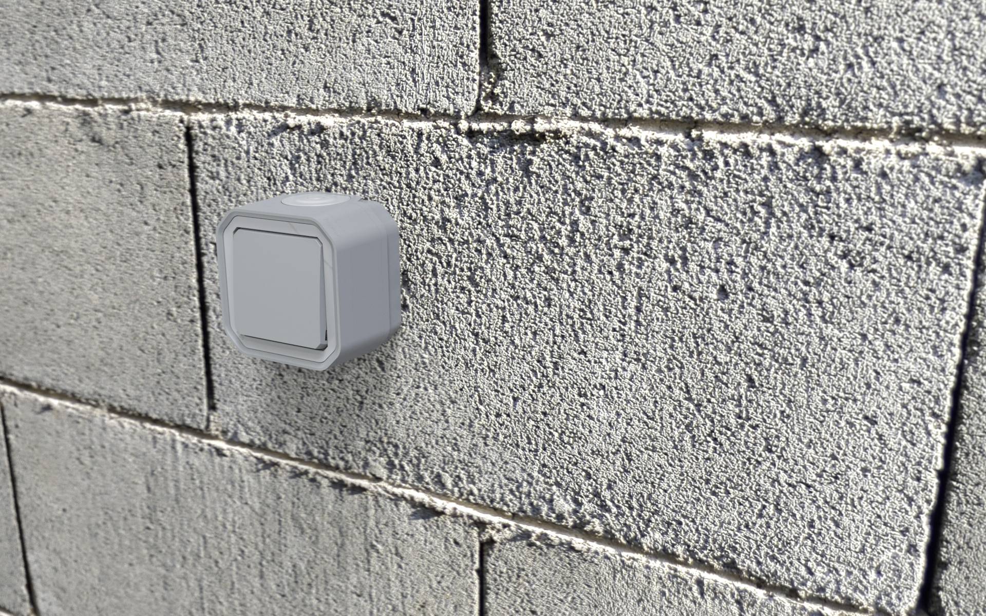 Light switch mounted on a grey brick wall.