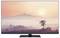 A television displays a landscape at sunset with mountains in the background and a solitary tree in the foreground.