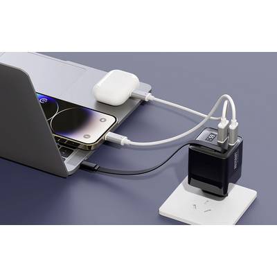 A laptop and a smartphone are connected to a charger. Beside them lies an open case with wireless earphones.