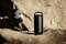 A black portable speaker sits on a rock in the foreground. In the background, a person is climbing a rock face.