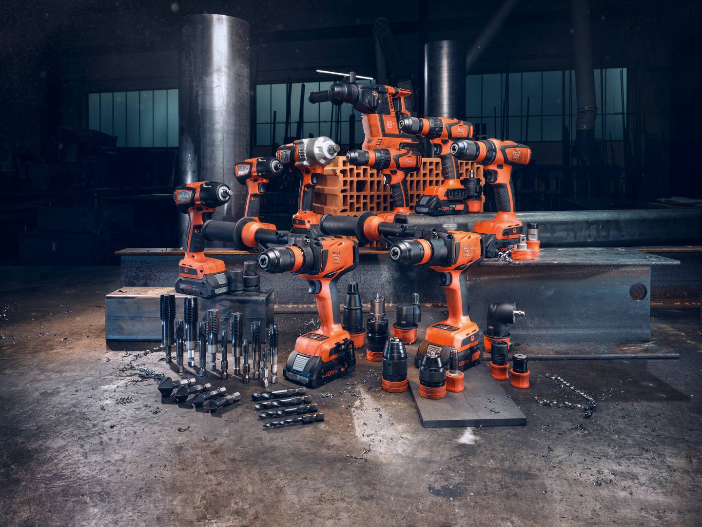 A 'robot' made from orange power drills and tools stands in a workshop; symbolising technology and creativity.