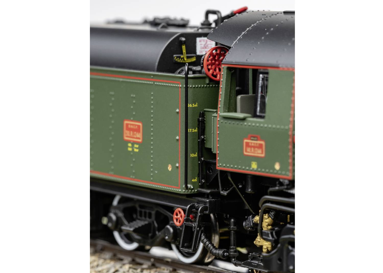 Model of a green steam locomotive with red details. The focus is on the detailed side view of the locomotive.