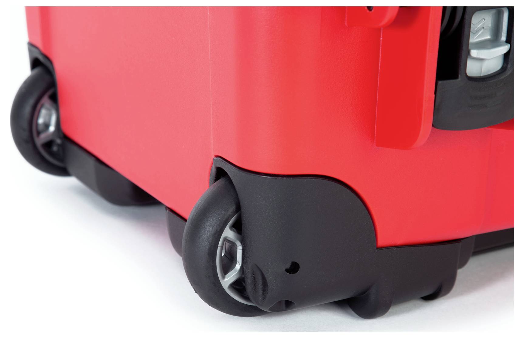 Red suitcase with black wheels, shown in close-up.