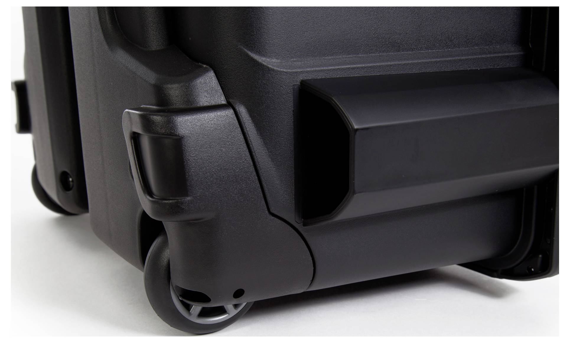 Close-up of a black hard-shell suitcase with wheels. The image captures details of the sturdy corners and attached castors.