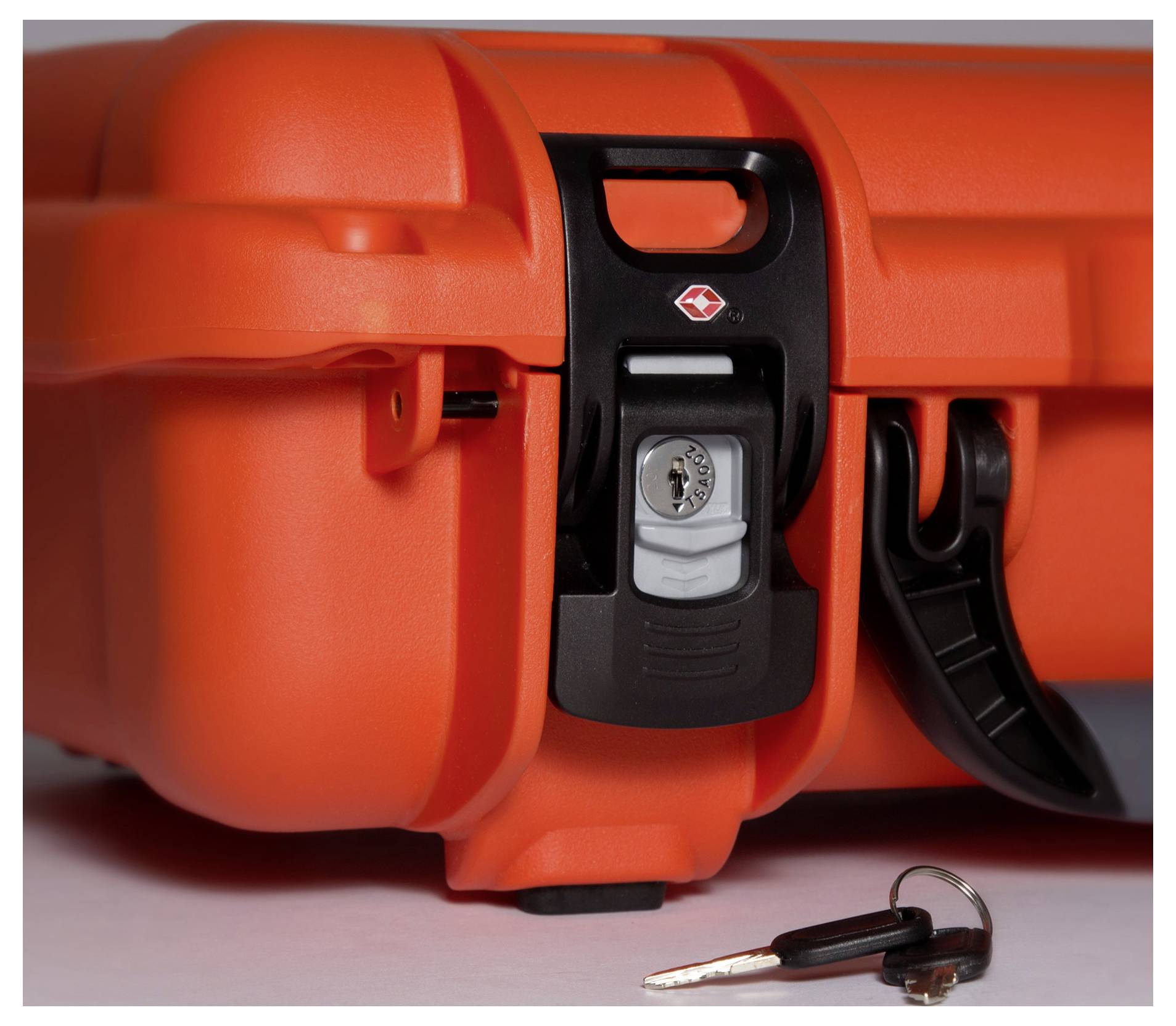 A sturdy orange suitcase with a security lock, with a silver key lying beside it on a white surface.