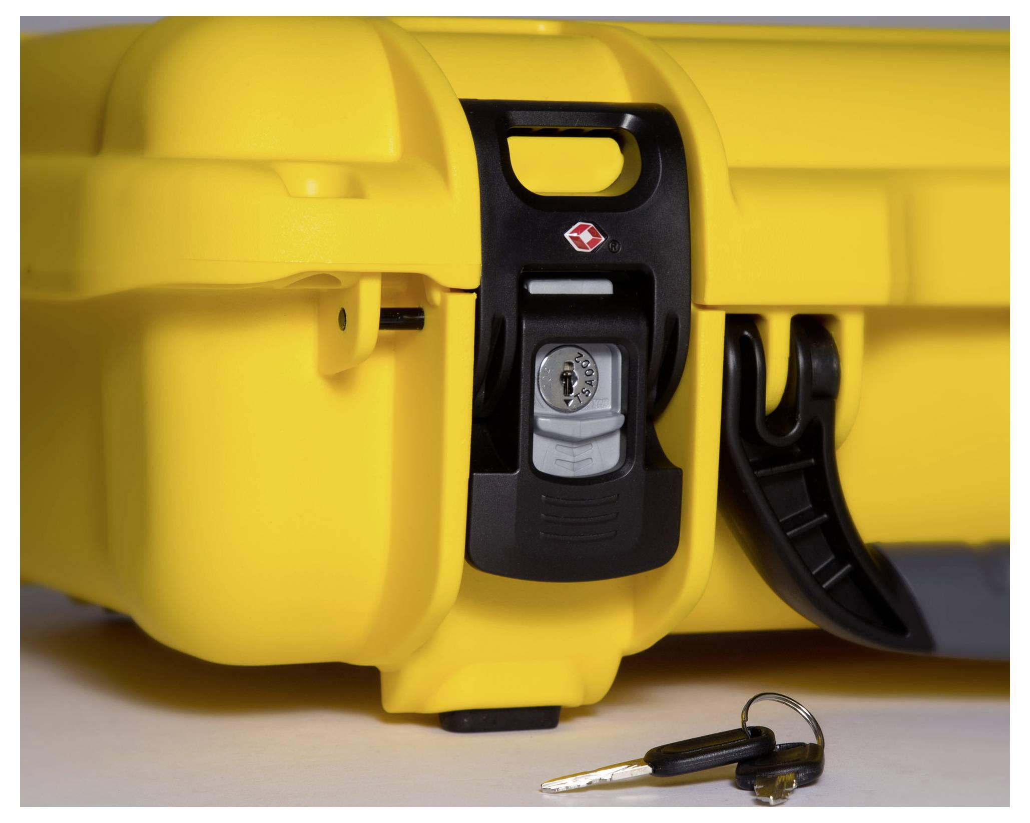 Yellow hard-shell suitcase with a black lock, with a key lying beside it. The suitcase appears to be securely locked.