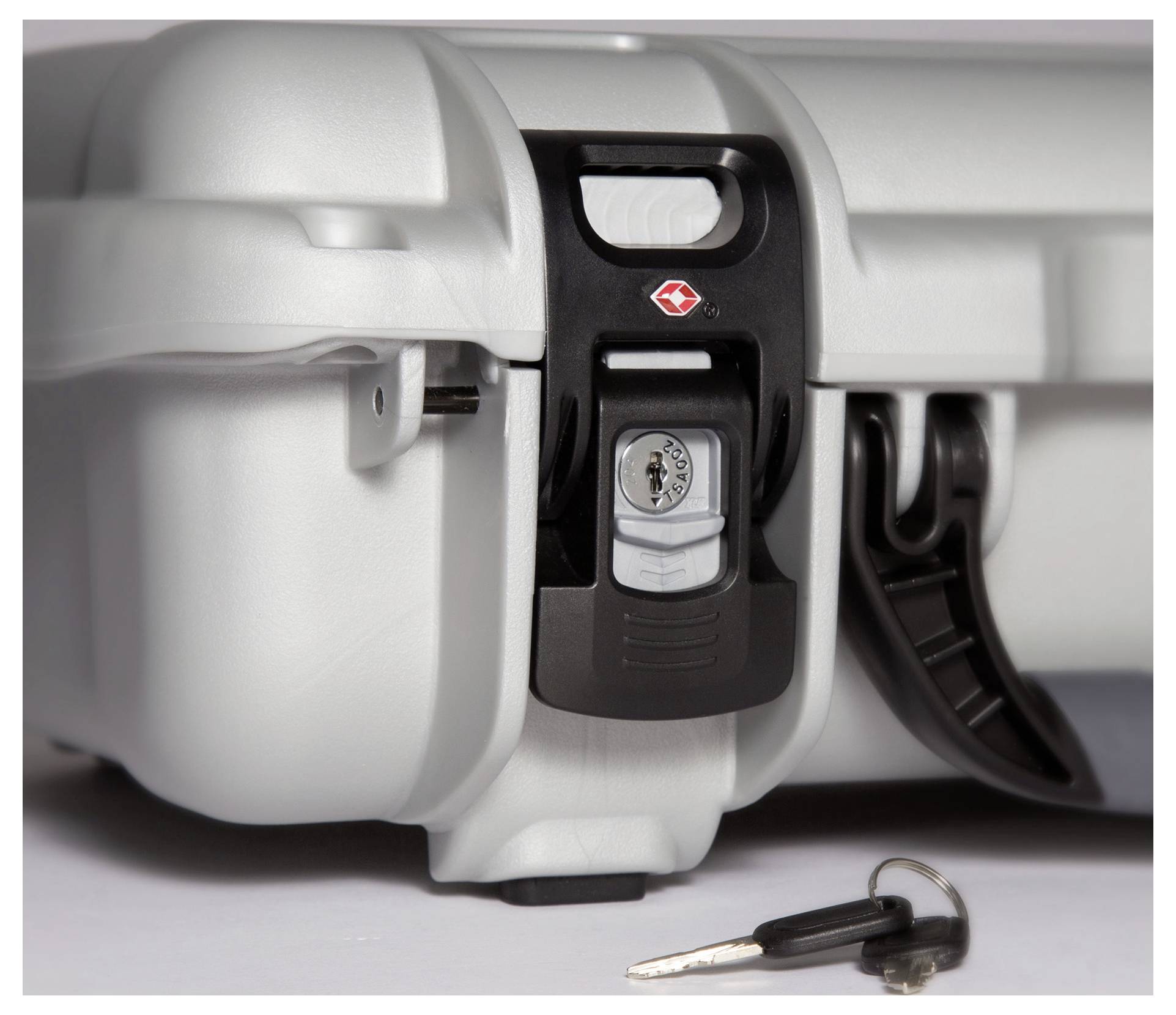Silver security briefcase with combination lock, sitting on a surface. A key with a black handle lies beside it.