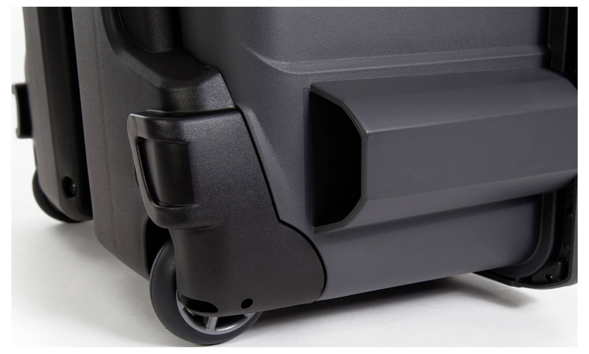 Close-up of a black suitcase with sturdy wheels and robust construction.