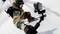 A snowboarder is gliding through fresh powder snow, holding an action camera on a selfie stick to film the ride.