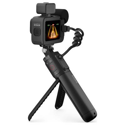 A black portable camera with a screen displays a subject with orange light effects. The camera is positioned on a folding tripod.