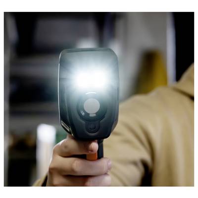 Person holding a handheld speed radar gun aimed at the camera, with a bright flash from the device.