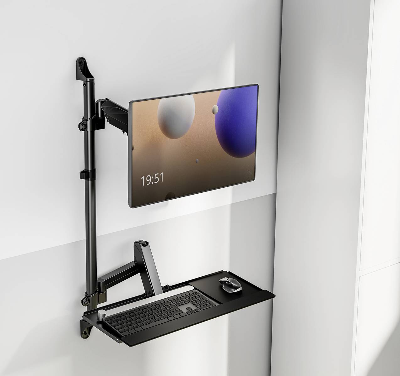 A computer monitor mounted on a wall bracket above a black keyboard and mouse; the screen displays spherical shapes and the time 19:51.