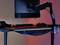 'Desk with a monitor, keyboard, headset and controller. The lighting is blue and pink, creating a relaxed atmosphere.'