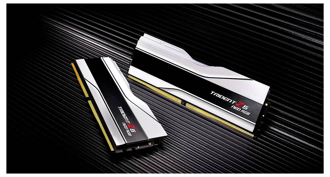 Two RAM modules from G.Skill, model 'Trident Z5', are lying on a ribbed, black surface. One module is flat, the other is standing upright.