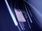 Lila Powerbank by 'Intenso' with attached charging cable, surrounded by dynamic lines on a blue background, moves swiftly.
