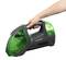 A person is holding a portable green and black vacuum cleaner with the label 'CLEANmaxx'.