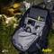 An open rucksack reveals multiple compartments filled with items such as a camera, sunglasses, a book and a laptop.