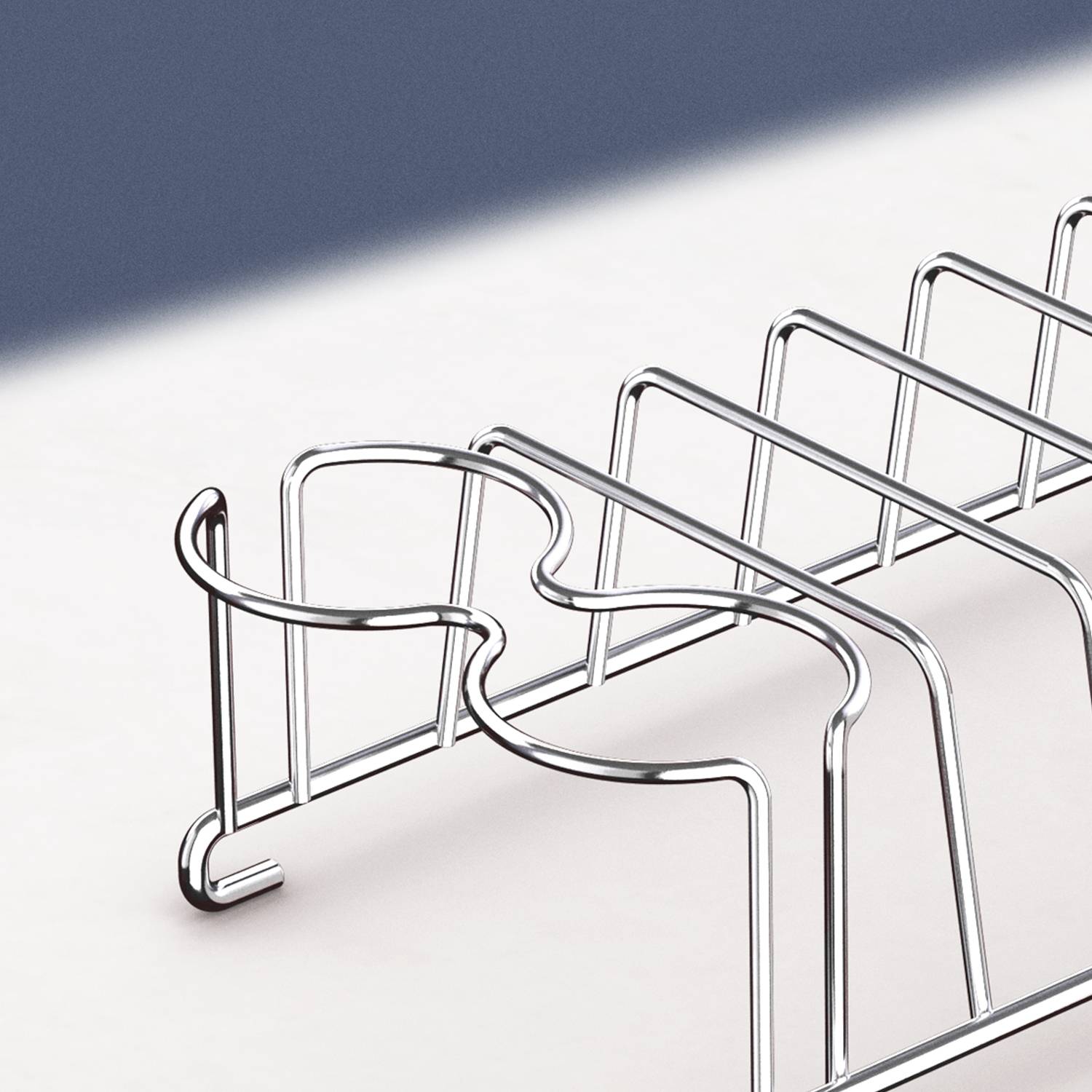 Metal pen holder with a curved design, empty, on a light background. Suitable for organising writing implements.