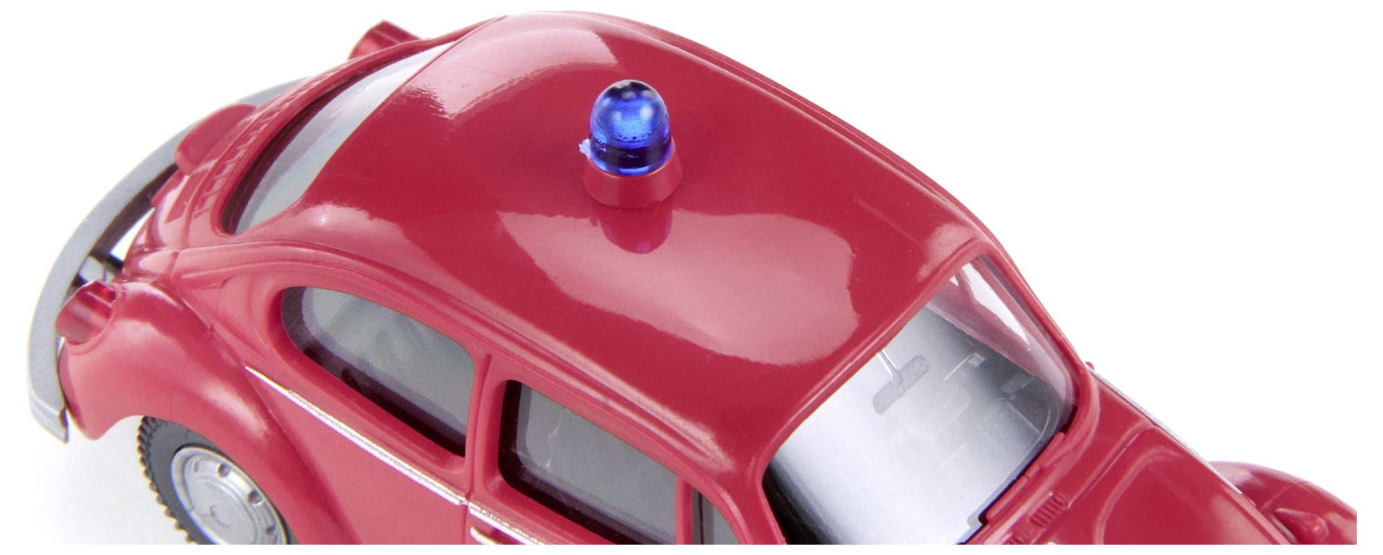 A red toy car in the shape of a beetle with a blue rotating light on its roof, viewed from an angle above.