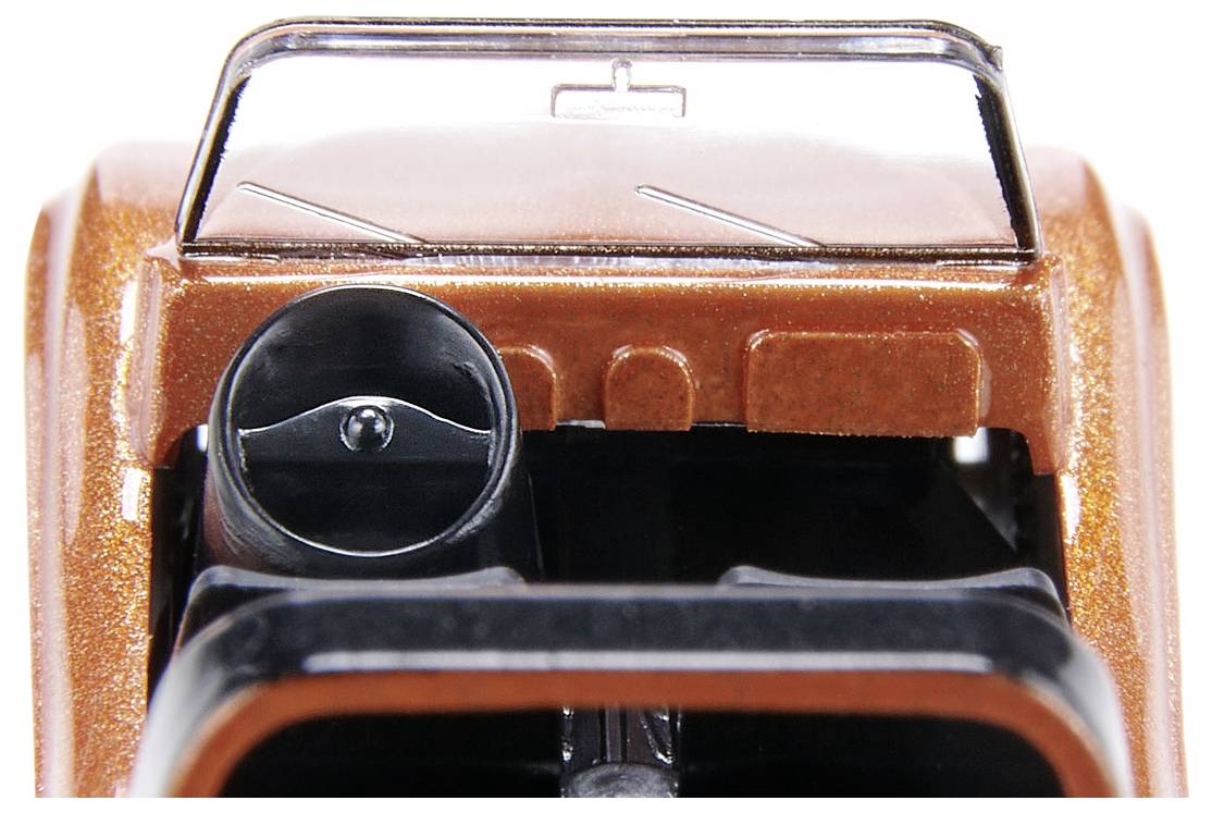 Close-up of a model vehicle with an orange casing and visible steering wheel. The dashboard is intricately recreated.