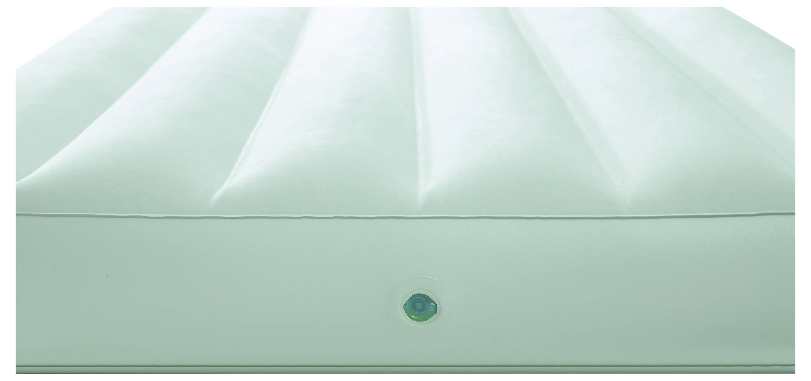 A green inflatable air mattress with a valve on the side. The surface has several parallel ridges.