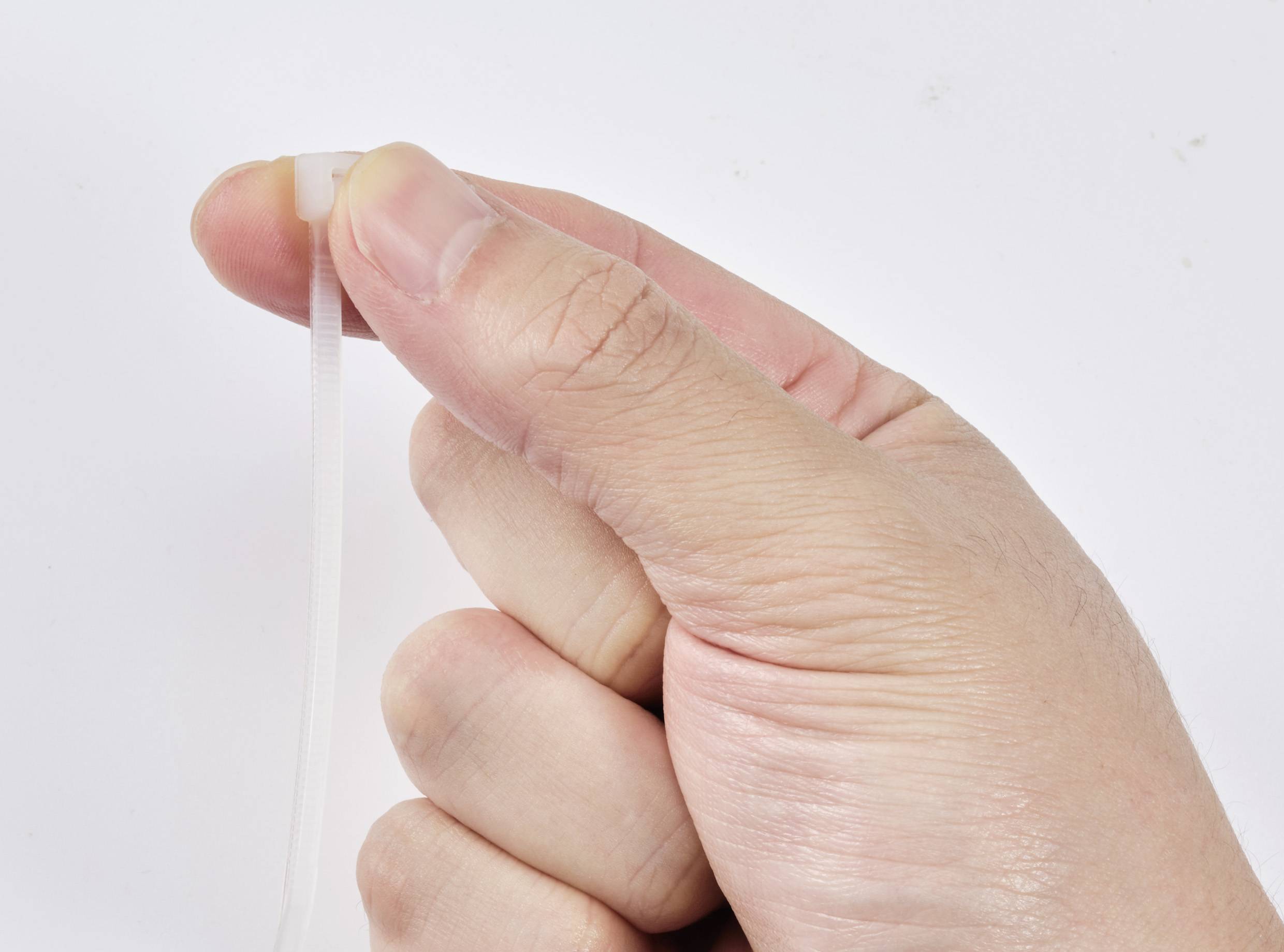 'Hand firmly gripping a cable tie'