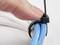 A person is securing blue and white cables with a black cable tie.