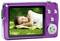 A woman is lying on a meadow, smiling, displayed on the screen of a purple camera. She is wearing a white top.