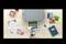 A printer with smartphone remote control prints a photo, surrounded by a wedding programme, photographs, and a notebook on a wooden table.