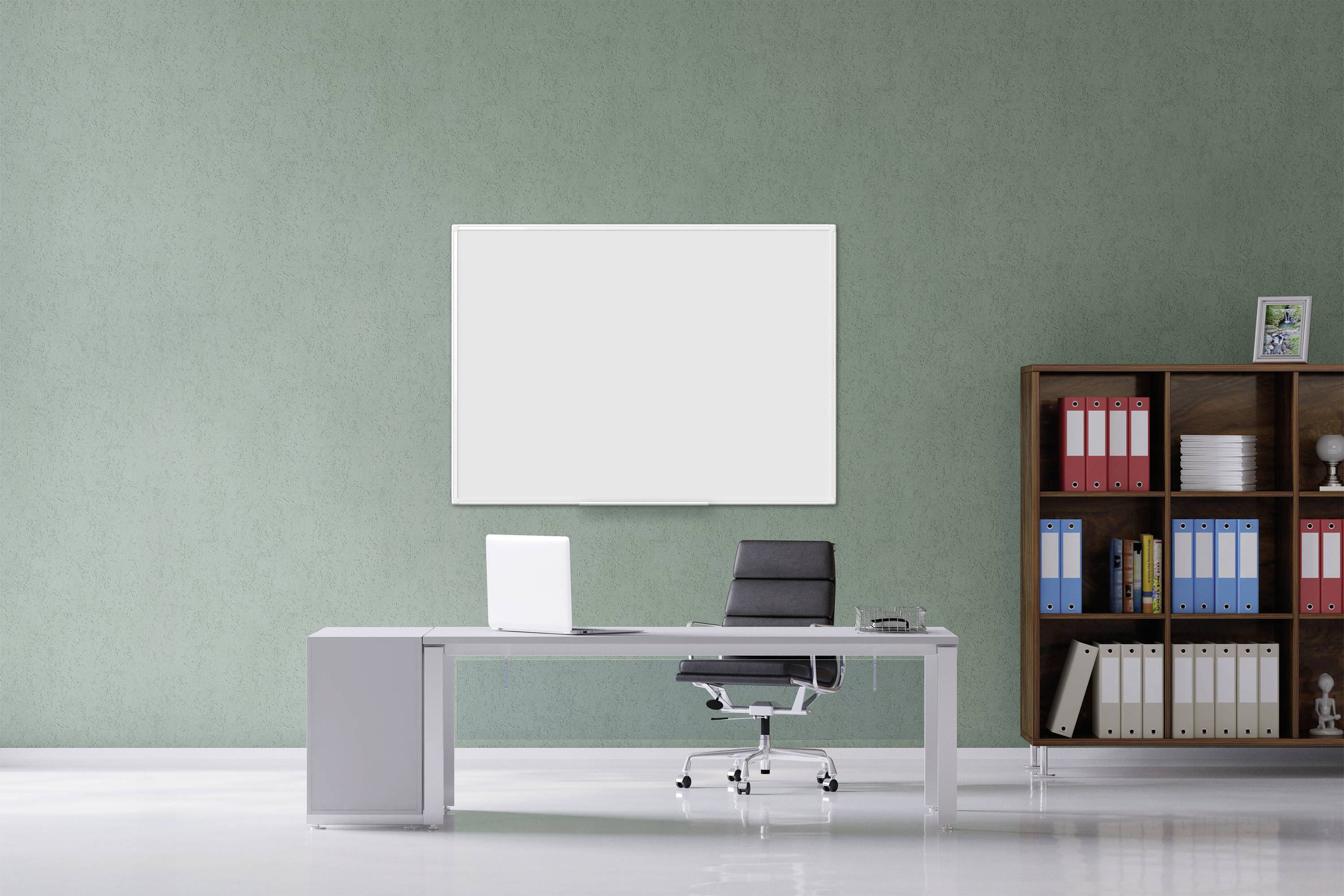 A modern office with a grey desk, black office chair, laptop and bookshelf. Blank whiteboard on the green wall.